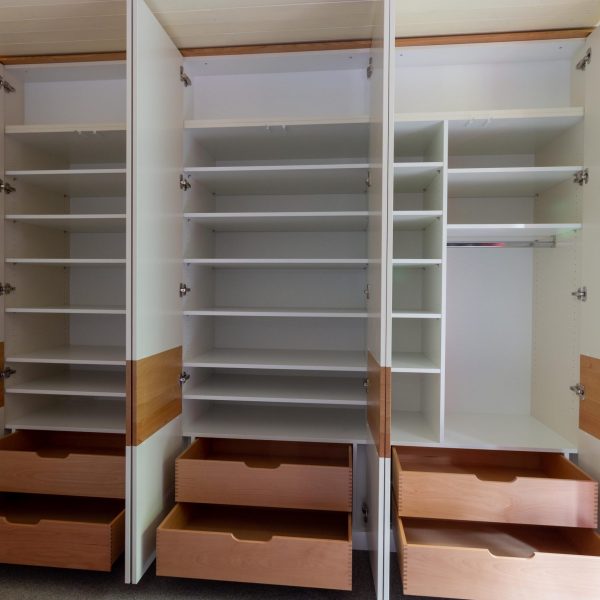 Ein echtes Stauraumwunder: Die Inneneinteilung vom Kleiderschrank auf Ma&szlig; mit Schubladen hinter den T&uuml;ren, Einlegeb&ouml;den und einer Kleiderstange