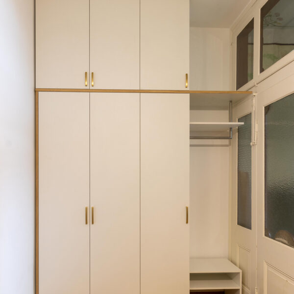 Garderobenschrank im Altbau mit wei&szlig;en Fronten, Messinggriffen und Akzenten in Eiche
