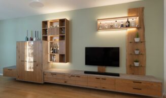Schreinerei-Freymark-Freiburg-_Wohnnraum_12-24_9591 Schreinermöbel in Eiche, schwarzen Griffen, Beton-Optik und variabler LED-Beleuchtung vor salbeigrün gestrichener Wand